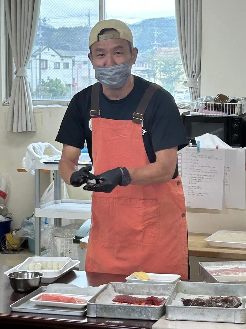寿司を握りながら、こちらに笑いかける店主